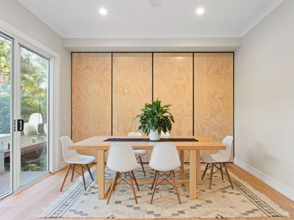 Photo of a contemporary dining room in Brisbane with grey walls, medium hardwood floors and brown floor.