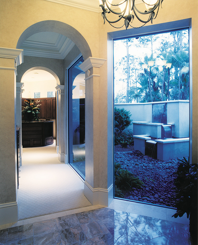 Photo of an expansive mediterranean hallway in Miami with beige walls and marble floors.