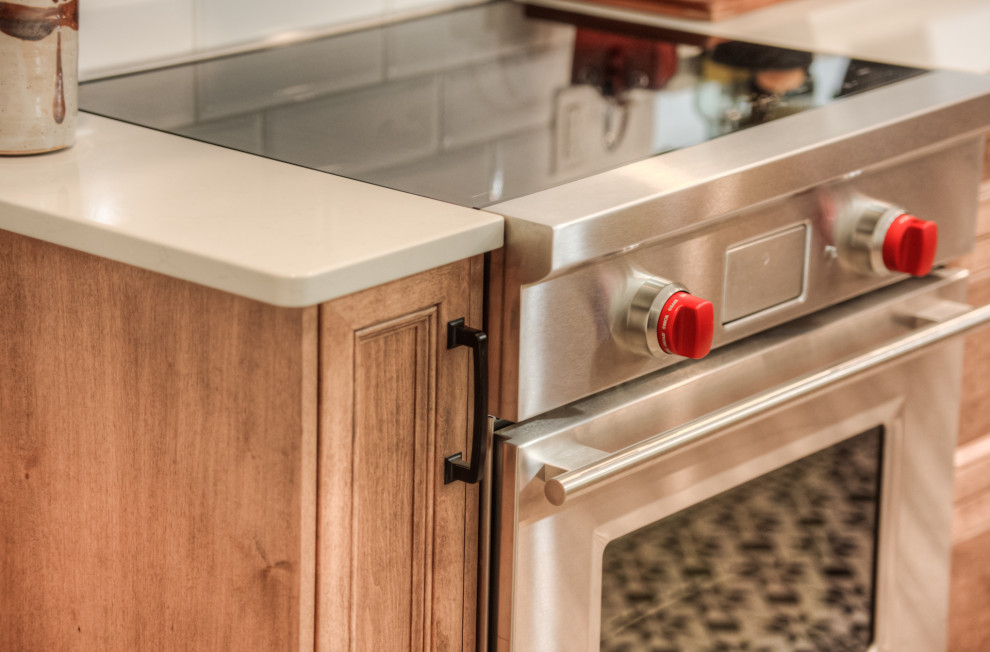 Kitchen - transitional l-shaped kitchen idea in Toronto with an undermount sink, shaker cabinets, light wood cabinets, white backsplash, stainless steel appliances, an island and white countertops