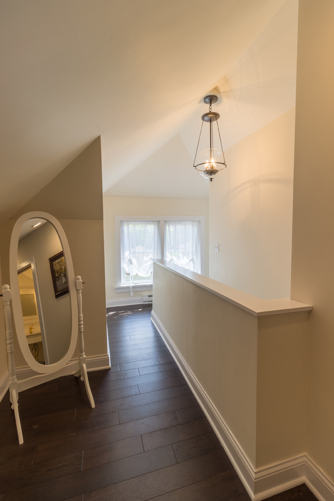 This is an example of a transitional hallway in Minneapolis with beige walls, dark hardwood floors and brown floor.