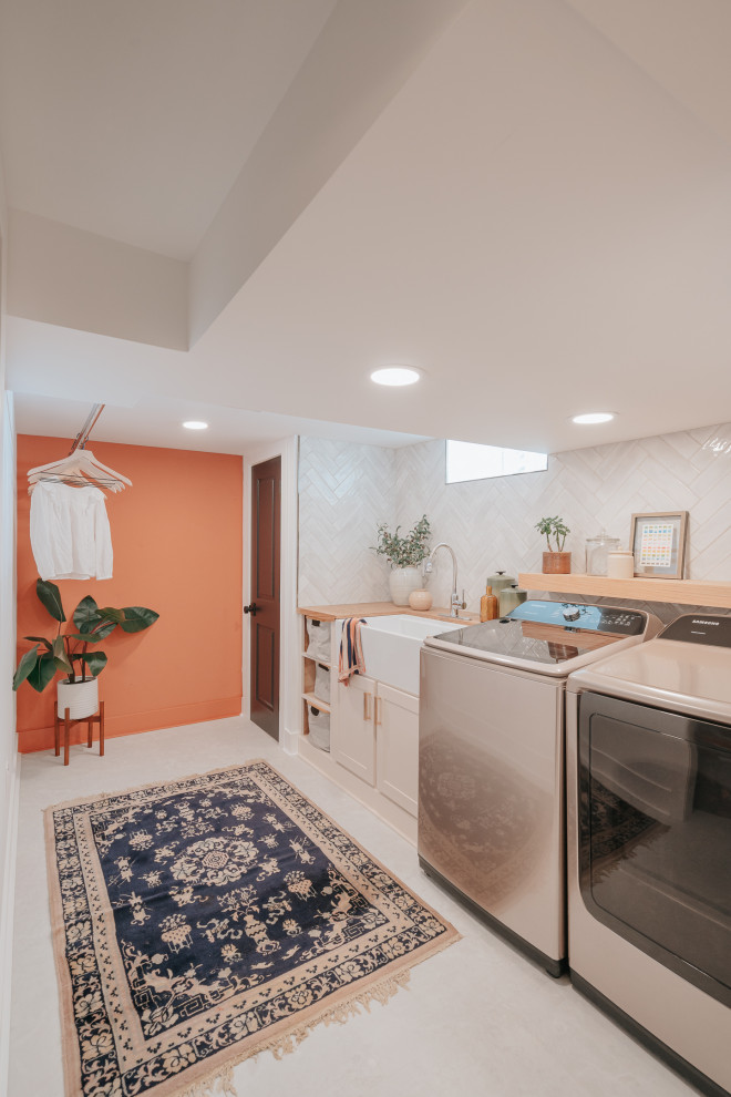 Small modern galley dedicated laundry room in Detroit with a farmhouse sink, shaker cabinets, beige cabinets, wood benchtops, a side-by-side washer and dryer and brown benchtop.