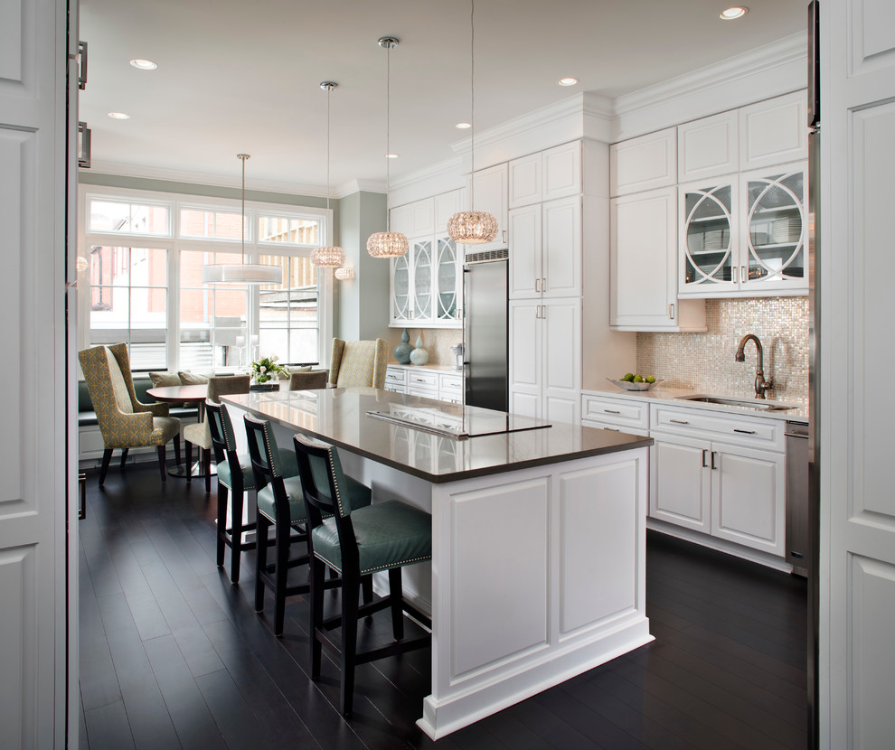 Design ideas for a mid-sized traditional l-shaped eat-in kitchen in DC Metro with raised-panel cabinets, stainless steel appliances, an undermount sink, white cabinets, dark hardwood floors, with island, solid surface benchtops, metallic splashback, metal splashback and brown floor.