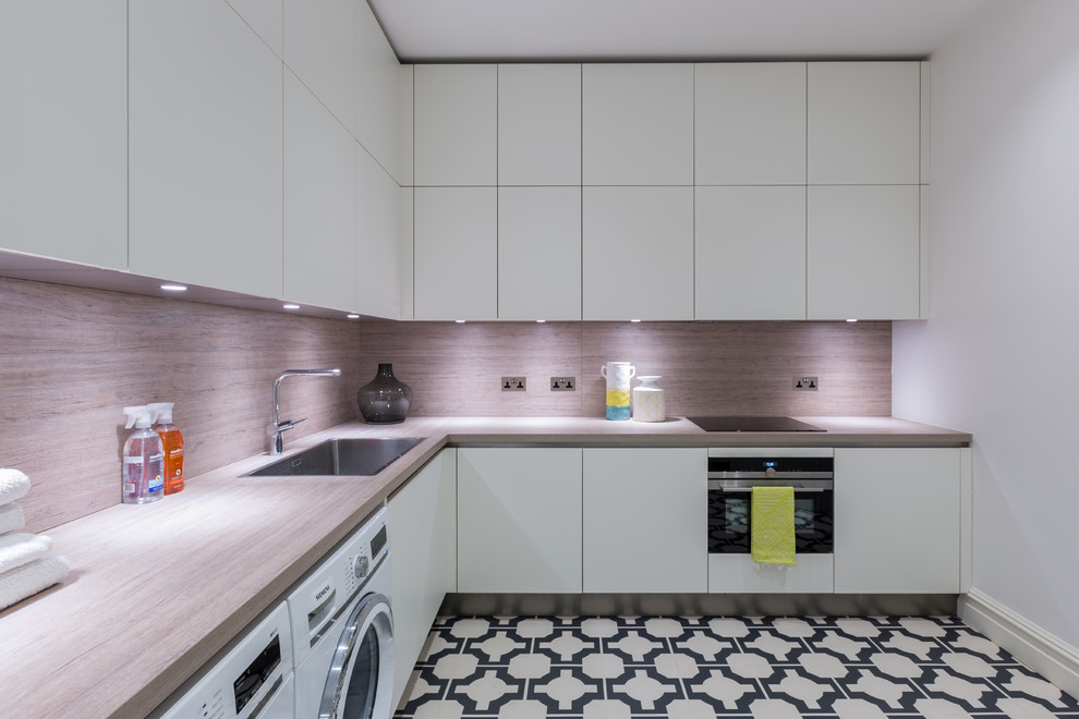 Photo of a mid-sized contemporary l-shaped kitchen in Gloucestershire with flat-panel cabinets, white cabinets, laminate benchtops, porcelain floors, multi-coloured floor, brown benchtop, a single-bowl sink and brown splashback.