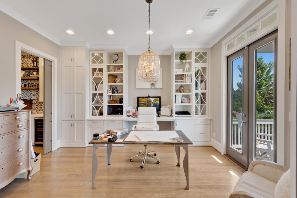 Ejemplo de despacho clásico renovado grande con paredes grises, suelo de madera clara, escritorio empotrado y suelo gris
