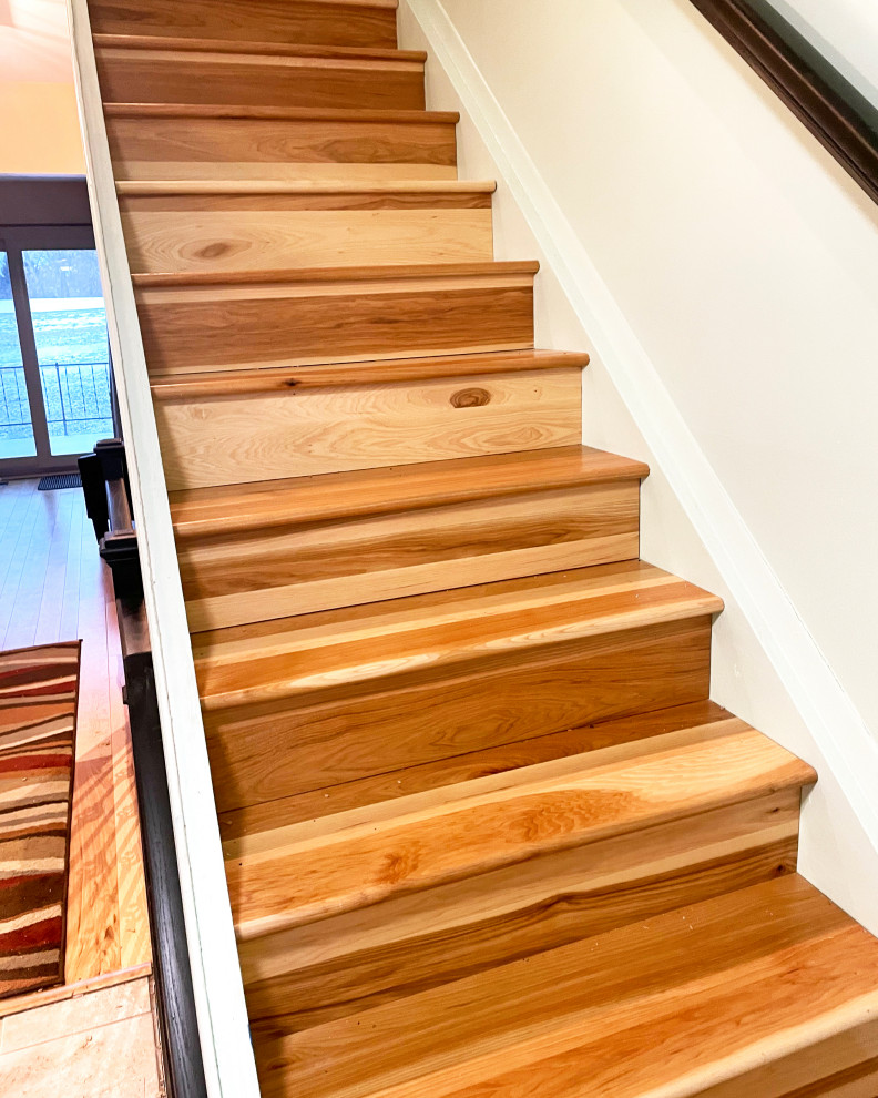 Ejemplo de escalera recta clásica de tamaño medio con escalones de madera, contrahuellas de madera y barandilla de madera