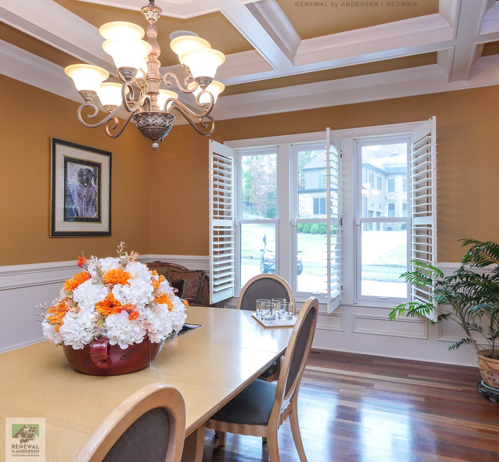 Photo of a mid-sized separate dining room in Atlanta with yellow walls, medium hardwood floors, no fireplace, coffered and decorative wall panelling.
