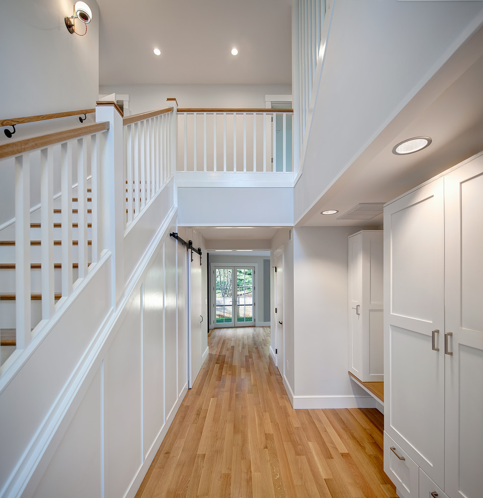 Inspiration for a mid-sized contemporary hallway in Boston with white walls and light hardwood floors.