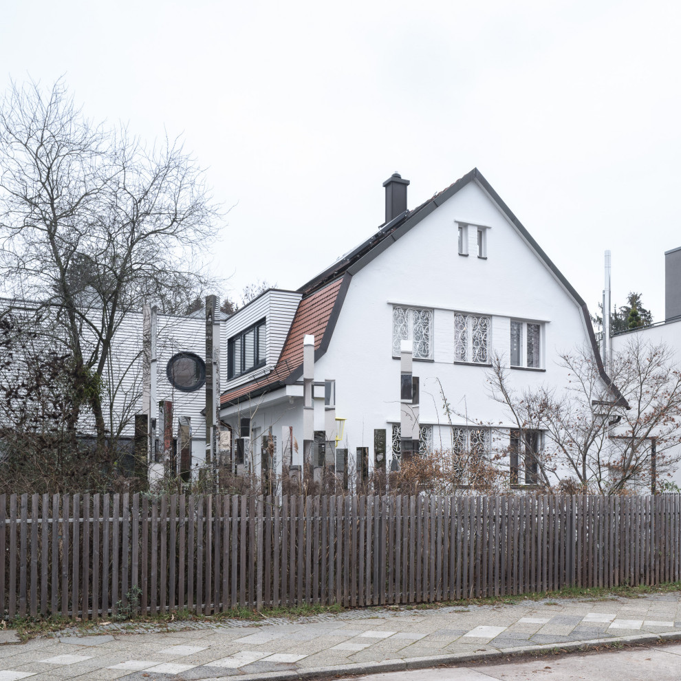 Großes, Zweistöckiges Klassisches Einfamilienhaus mit Putzfassade, weißer Fassadenfarbe, Mansardendach, Ziegeldach, rotem Dach und Dachgaube in Berlin