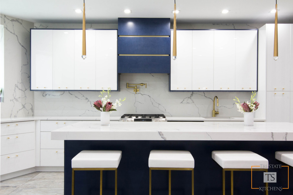 Inspiration for a large contemporary l-shaped eat-in kitchen in New York with an undermount sink, flat-panel cabinets, white cabinets, quartzite benchtops, white splashback, stone slab splashback, stainless steel appliances, ceramic floors, with island, multi-coloured floor and white benchtop.