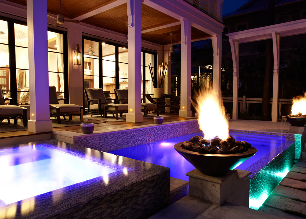 This is an example of a contemporary backyard patio in Miami with a fire feature and natural stone pavers.