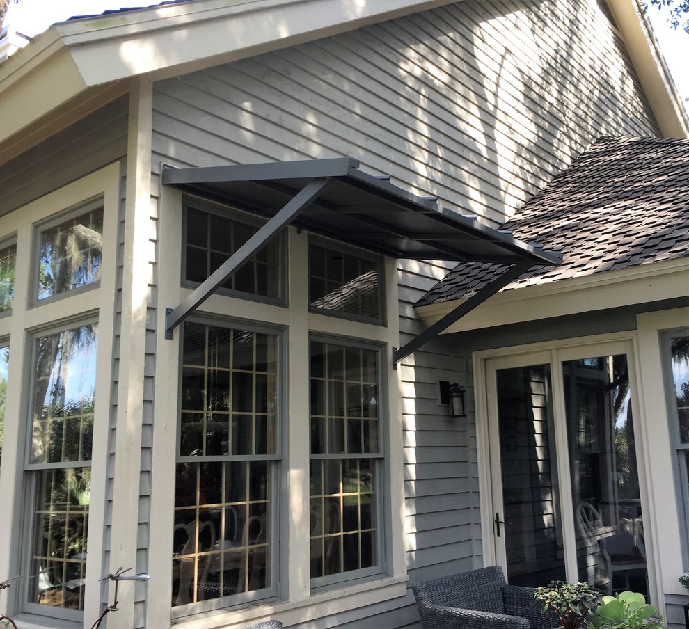 Small traditional backyard patio in Jacksonville with an awning.