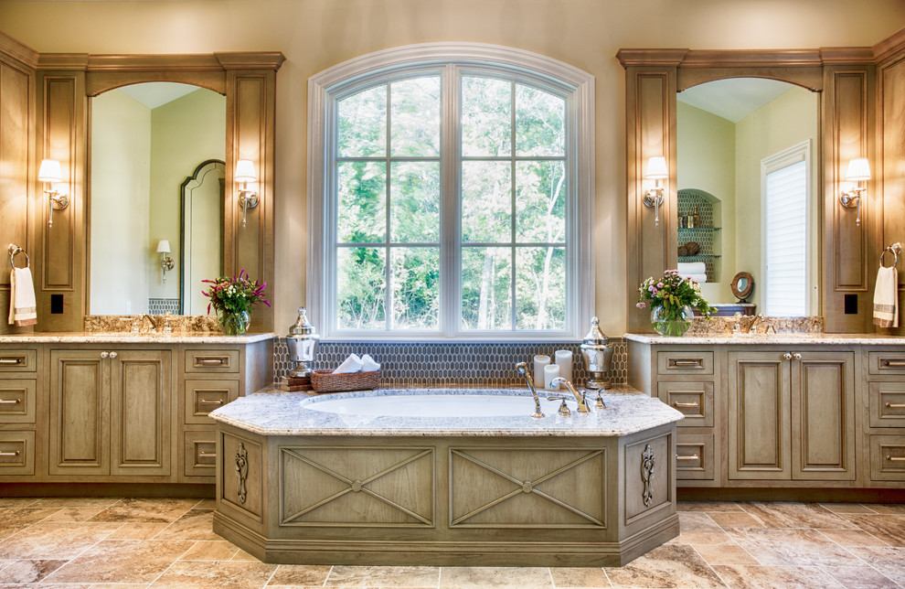 Large traditional master bathroom in St Louis with an undermount sink, raised-panel cabinets, distressed cabinets, granite benchtops, an undermount tub, an open shower, a two-piece toilet, brown tile, glass tile, beige walls and travertine floors.