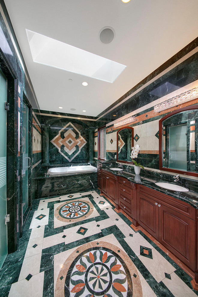 Expansive bathroom in Seattle with raised-panel cabinets, an alcove tub, an alcove shower, green tile, marble, green walls, marble floors, an undermount sink, marble benchtops, multi-coloured floor, a hinged shower door, black benchtops, a double vanity and a built-in vanity.
