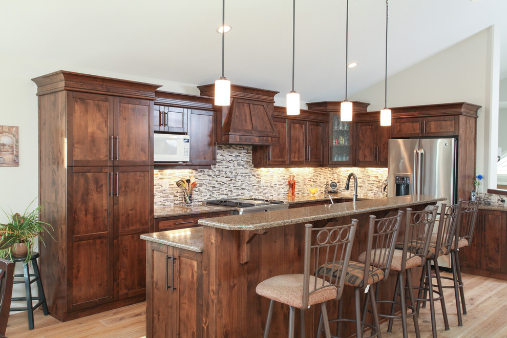 Example of a transitional l-shaped light wood floor eat-in kitchen design in Calgary with an undermount sink, shaker cabinets, dark wood cabinets, quartz countertops, gray backsplash, matchstick tile backsplash, stainless steel appliances and an island