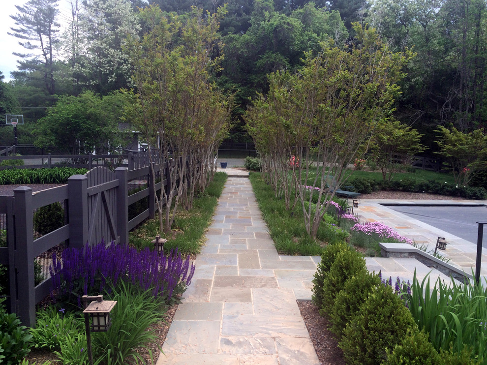 This is an example of a large traditional backyard formal garden in DC Metro with natural stone pavers.