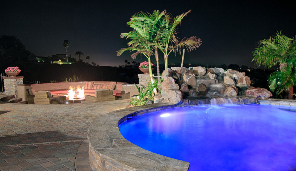 Inspiration for a large transitional backyard patio in San Diego with a water feature, concrete pavers and a roof extension.