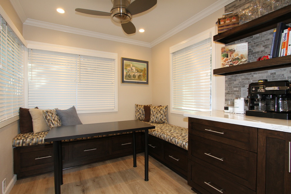 Open concept kitchen - small transitional l-shaped light wood floor and beige floor open concept kitchen idea in Orange County with an undermount sink, shaker cabinets, dark wood cabinets, quartz countertops, beige backsplash, glass sheet backsplash, stainless steel appliances and no island