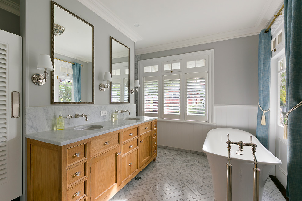 Traditional bathroom in Sydney with an undermount sink, medium wood cabinets, a freestanding tub, grey walls and shaker cabinets.