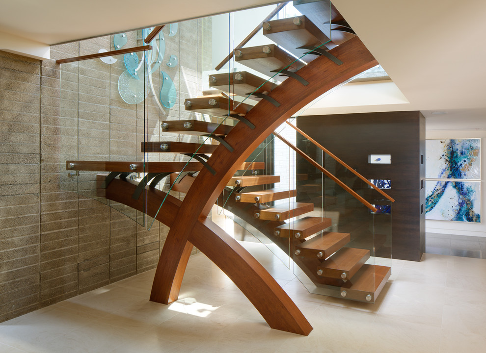 This is an example of a contemporary wood u-shaped staircase in San Diego with open risers and glass railing.