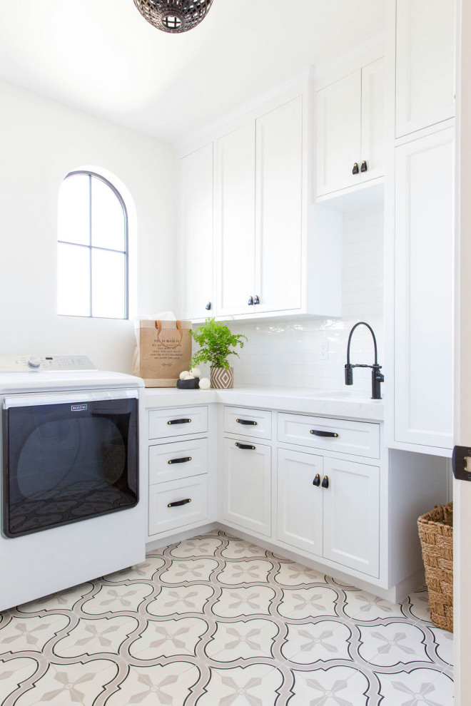 Inspiration for a mid-sized transitional l-shaped utility room in Sacramento with an undermount sink, shaker cabinets, white cabinets, white walls, an integrated washer and dryer, multi-coloured floor and white benchtop.