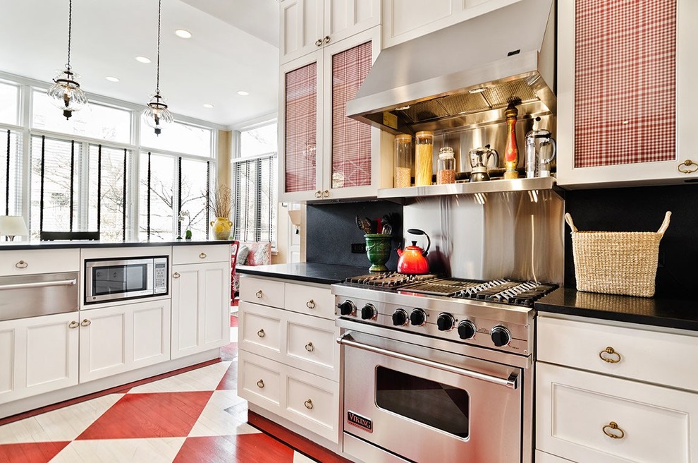 Inspiration for a traditional kitchen in Chicago with recessed-panel cabinets, white cabinets, black splashback, stainless steel appliances and painted wood floors.