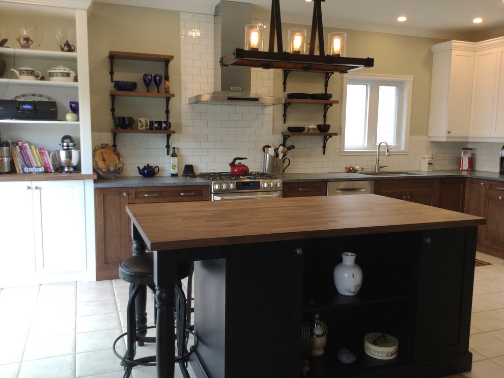 Example of a mid-sized transitional l-shaped kitchen design in Ottawa with an undermount sink, shaker cabinets, dark wood cabinets, soapstone countertops, white backsplash, ceramic backsplash, stainless steel appliances and an island