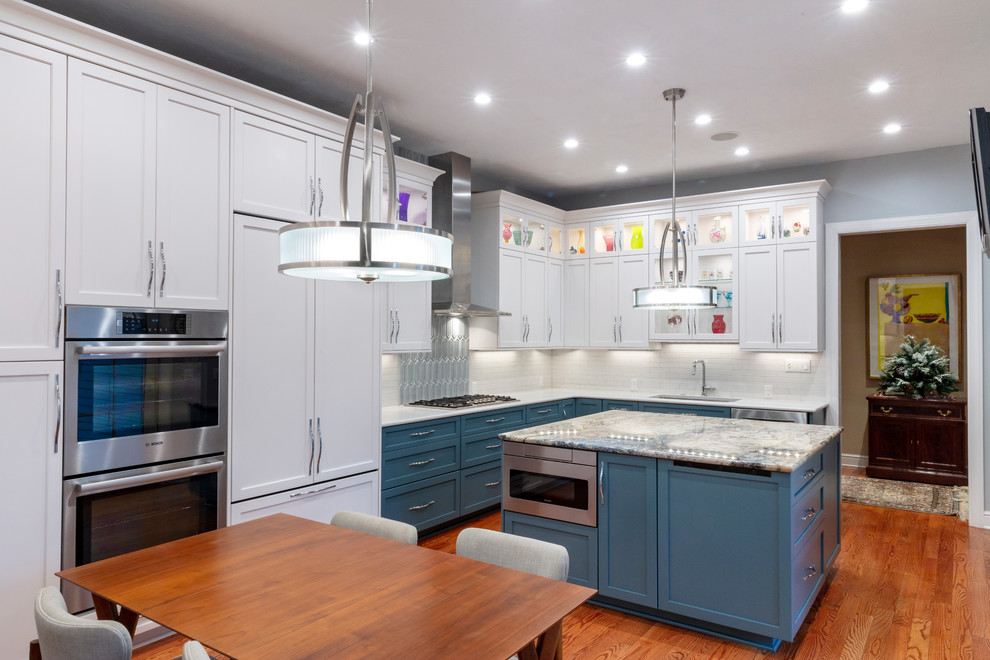 Transitional kitchen photo with white backsplash and stainless steel appliances
