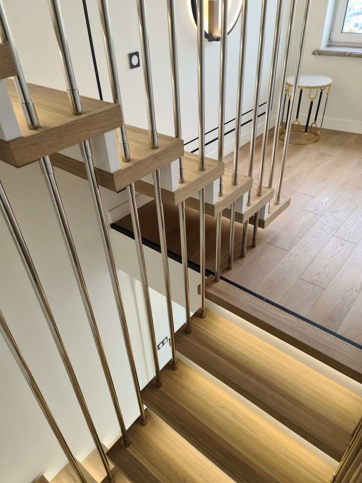 Photo of a large contemporary wood u-shaped staircase in Moscow with wood risers, metal railing and brick walls.