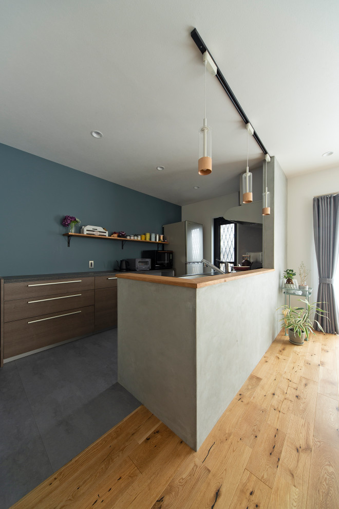 This is an example of a small scandinavian galley open plan kitchen in Osaka with brown cabinets, ceramic floors, with island and grey floor.