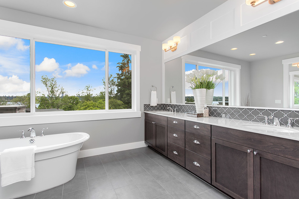 Large transitional master bathroom in Seattle with shaker cabinets, dark wood cabinets, a freestanding tub, gray tile, glass tile, grey walls, an undermount sink and engineered quartz benchtops.