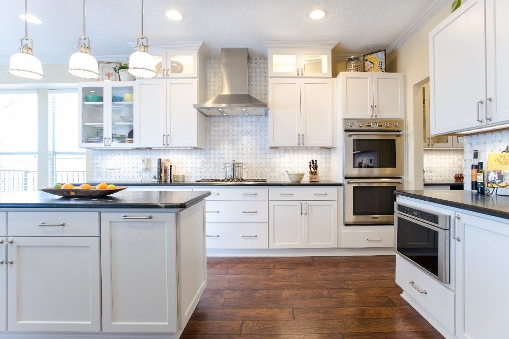 This is an example of a large country l-shaped kitchen in Miami with a double-bowl sink, shaker cabinets, white cabinets, yellow splashback, marble splashback, stainless steel appliances, dark hardwood floors, with island and brown floor.