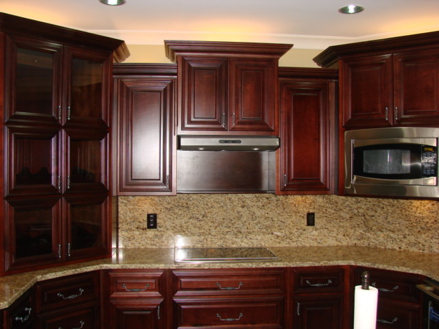 Mid-sized traditional galley eat-in kitchen in Atlanta with raised-panel cabinets, dark wood cabinets, granite benchtops, beige splashback, stone tile splashback, stainless steel appliances, ceramic floors and a peninsula.