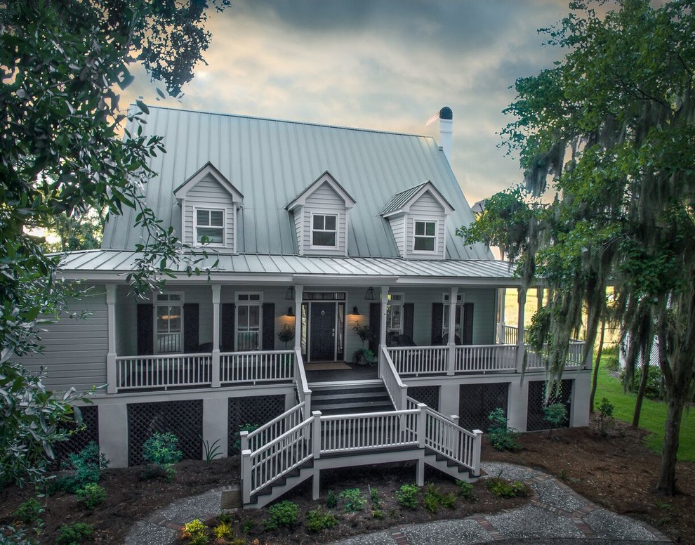 Photo of a large beach style two-storey grey house exterior in Atlanta with wood siding, a gable roof and a metal roof.