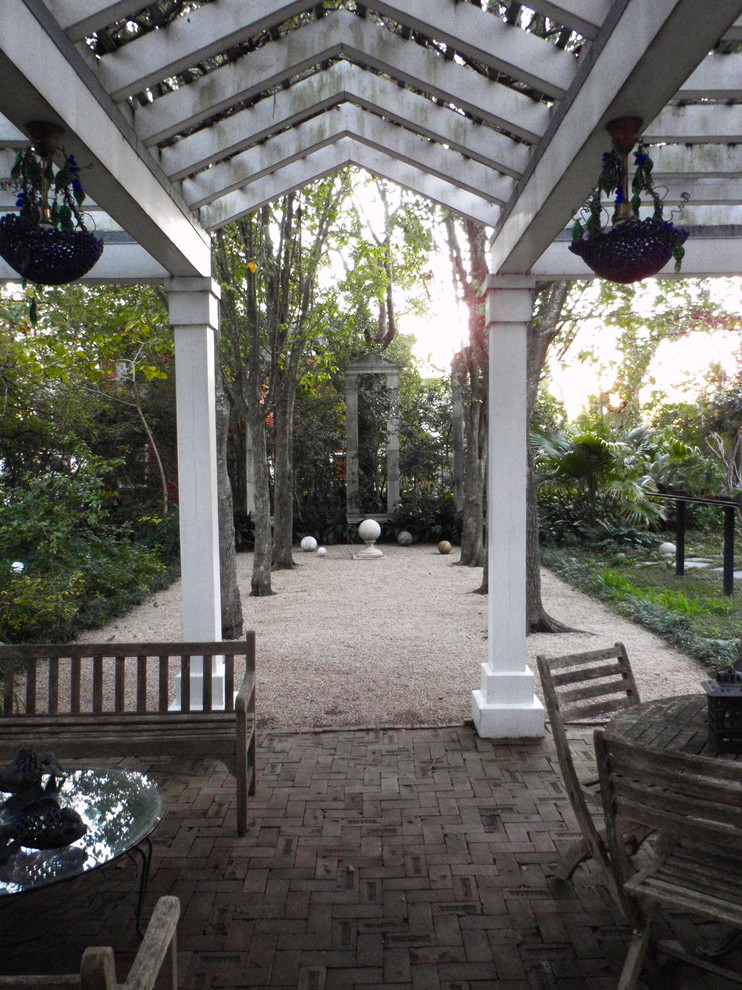 Design ideas for a traditional side yard verandah in Houston with brick pavers and a pergola.
