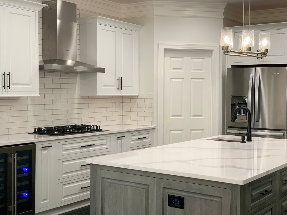 Example of a transitional marble floor and black floor eat-in kitchen design with an undermount sink, quartz countertops, ceramic backsplash, stainless steel appliances, an island and white countertops