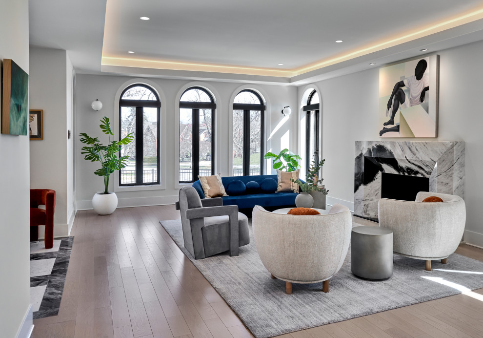 Идея дизайна: большая парадная гостиная комната в современном стиле с белыми стенами, светлым паркетным полом, стандартным камином, фасадом камина из камня и многоуровневым потолком без телевизора