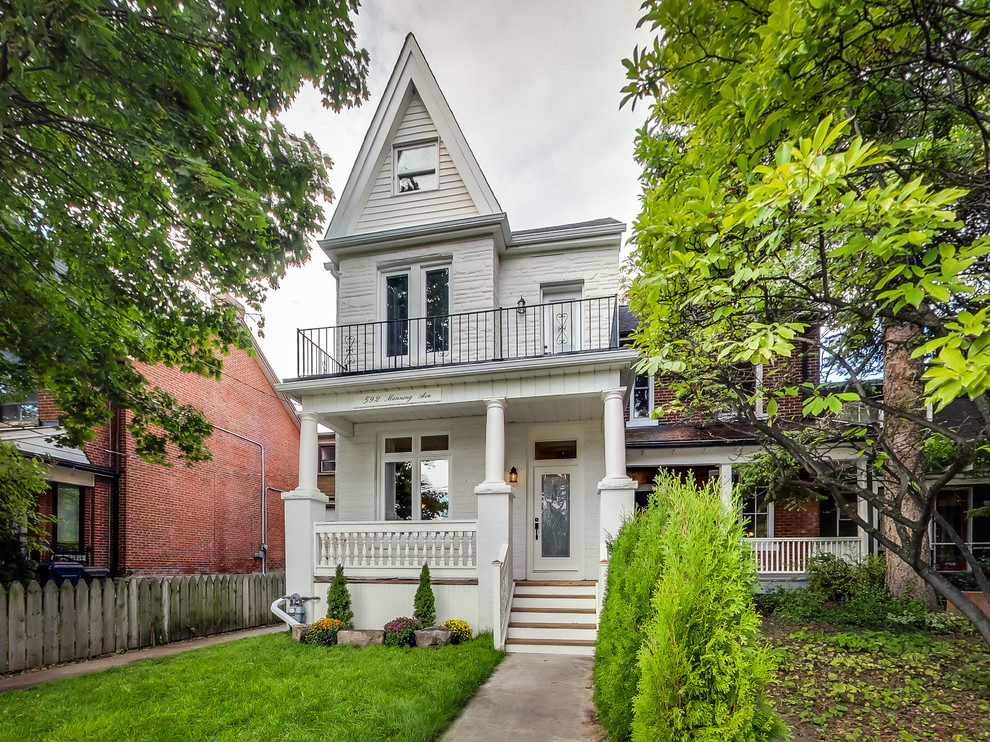 Photo of a mid-sized traditional two-storey white exterior in Toronto with a gable roof.