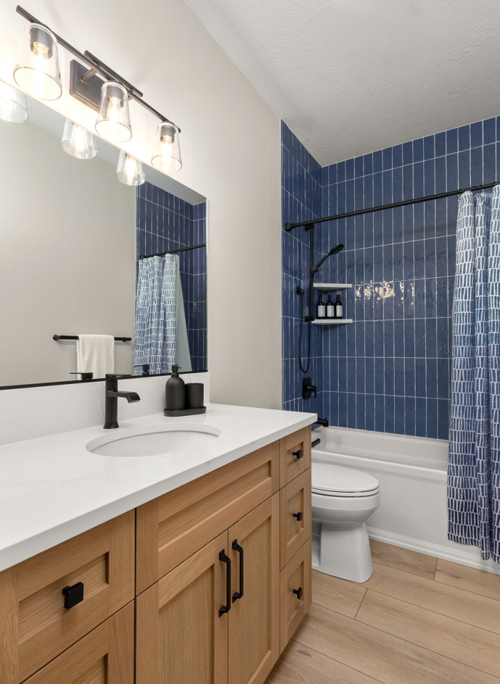 Imagen de cuarto de baño único campestre con armarios estilo shaker, bañera empotrada, combinación de ducha y bañera, baldosas y/o azulejos azules, baldosas y/o azulejos de cerámica, lavabo bajoencimera, encimera de cuarzo compacto y ducha con cortina