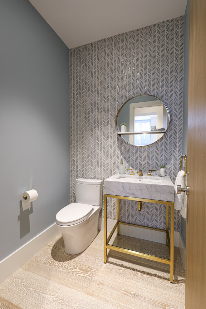 This is an example of a small contemporary cloakroom in Boston with a one-piece toilet, blue tiles, mosaic tiles, blue walls, light hardwood flooring, a submerged sink, marble worktops, white floors, grey worktops and a freestanding vanity unit.
