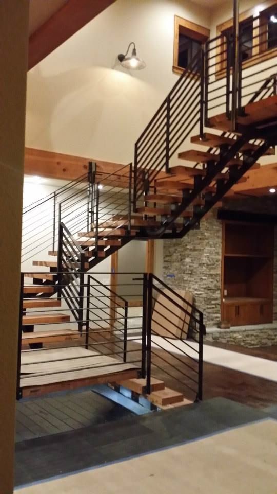 This is an example of a large wood floating staircase in Portland with metal risers.