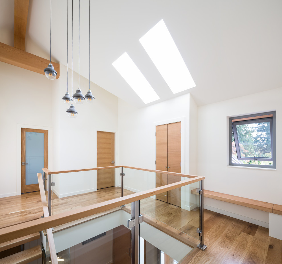 Photo of a large contemporary hallway in Vancouver with white walls, medium hardwood floors and brown floor.