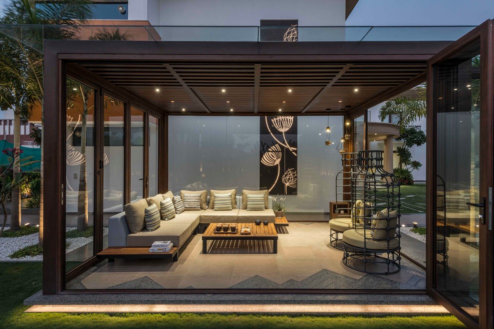 Design ideas for a mid-sized contemporary backyard patio in Ahmedabad with a pergola and tile.