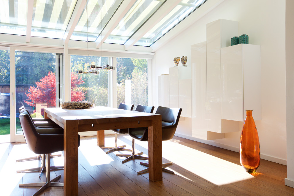 Foto di una veranda design di medie dimensioni con pavimento in legno massello medio, soffitto in vetro e pavimento marrone