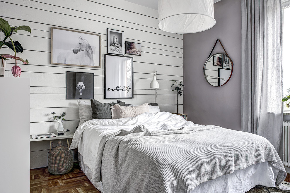Photo of a scandinavian bedroom in Stockholm with purple walls and light hardwood floors.
