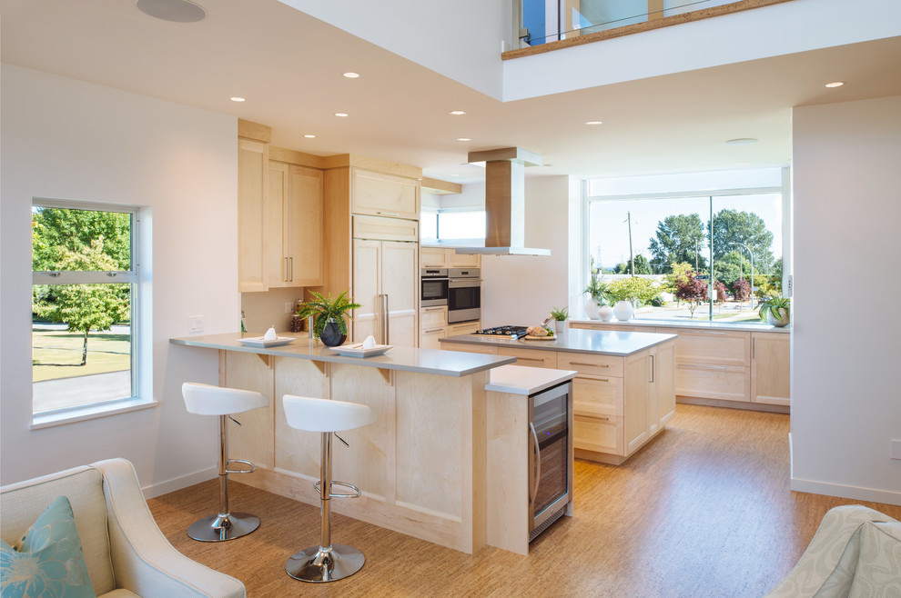 Photo of a large contemporary u-shaped open plan kitchen in Vancouver with an undermount sink, shaker cabinets, light wood cabinets, quartz benchtops, white splashback, panelled appliances, cork floors and with island.