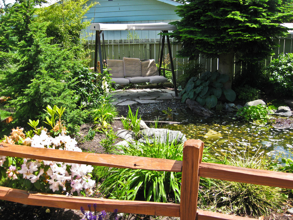 Photo of a mid-sized rustic full sun backyard stone water fountain landscape in Seattle for spring.
