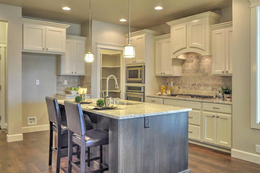 Small transitional l-shaped medium tone wood floor eat-in kitchen photo in Boise with an undermount sink, recessed-panel cabinets, white cabinets, granite countertops, beige backsplash, stone tile backsplash, stainless steel appliances and an island