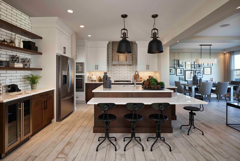 Photo of a country u-shaped open plan kitchen in Calgary with an undermount sink, shaker cabinets, dark wood cabinets, white splashback, subway tile splashback, stainless steel appliances and a peninsula.