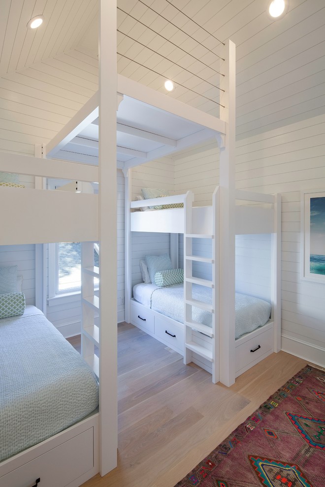 Design ideas for a beach style kids' bedroom in New York with light hardwood floors and white walls.