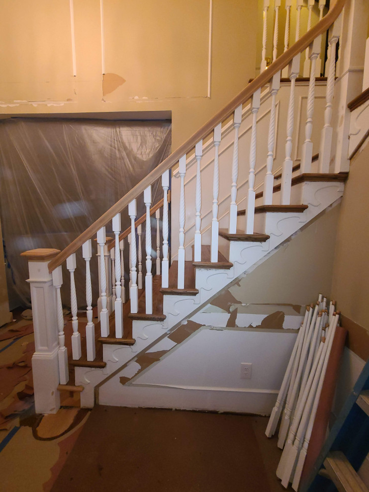 Large ornate wooden l-shaped wood railing staircase photo in New York with travertine risers